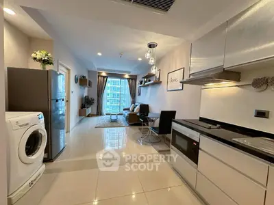 Modern open-plan kitchen and living room with sleek appliances and city view.