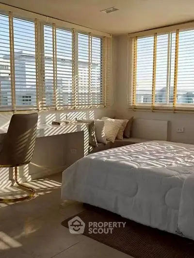 Bright and cozy bedroom with large windows and modern decor