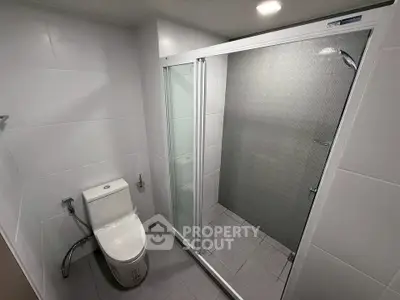 Modern bathroom with sleek shower and toilet in contemporary design.