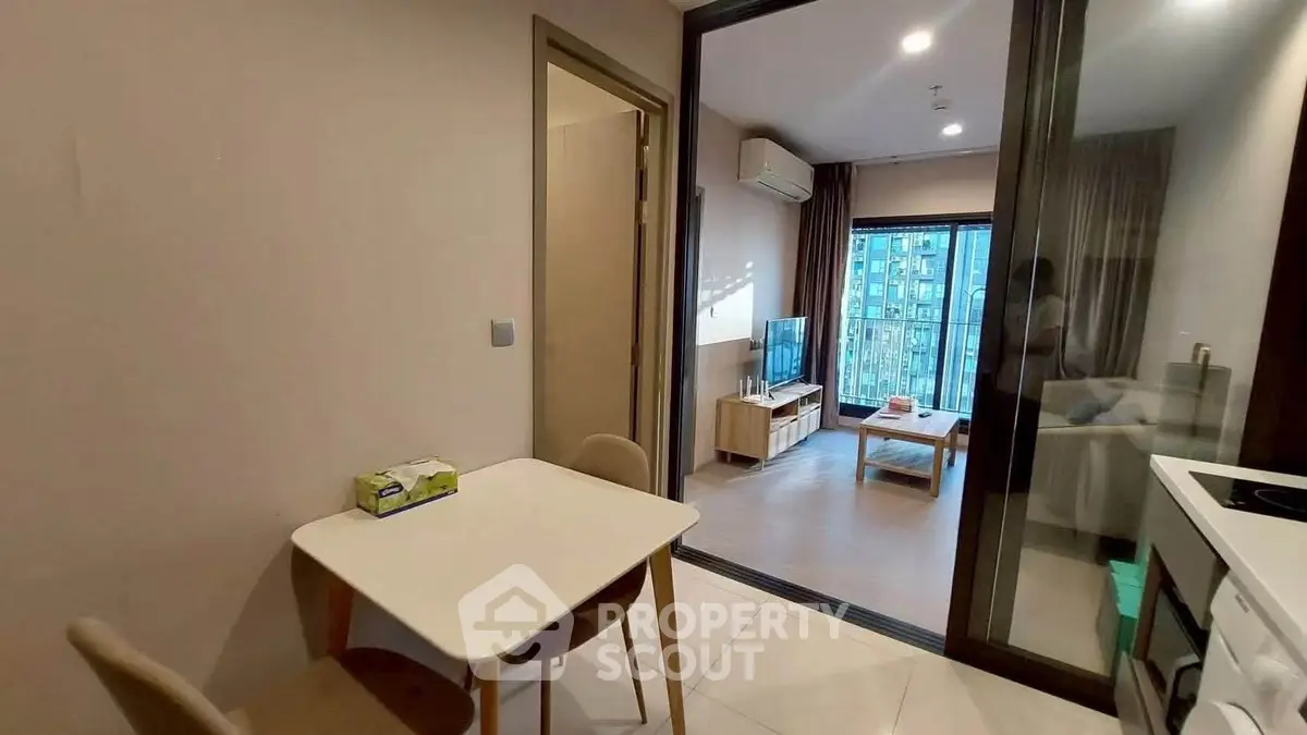 Modern apartment interior with open layout kitchen and cozy living room with balcony view.