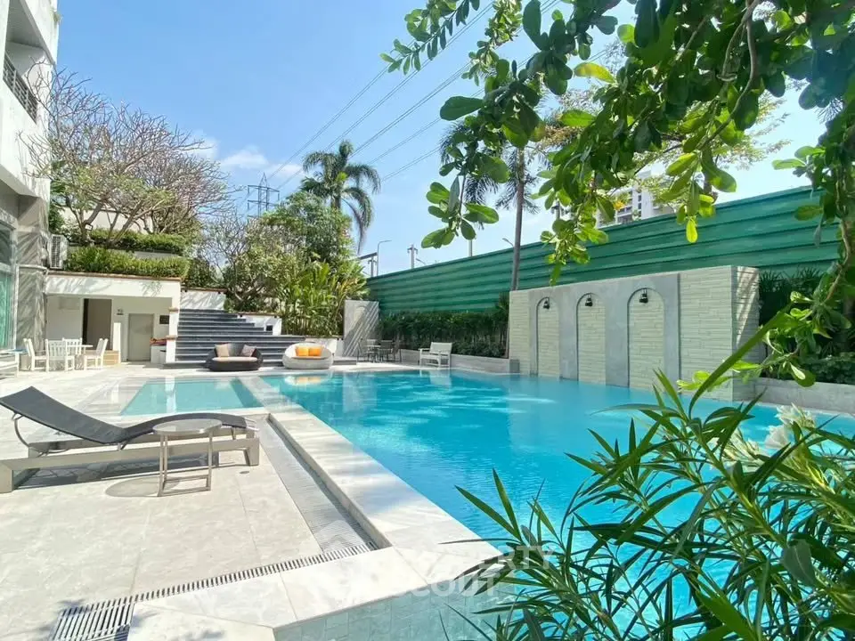 Luxurious outdoor pool area with lush greenery and modern design, perfect for relaxation and leisure.