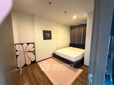 Cozy bedroom with modern decor and wooden flooring, featuring a stylish bed and artistic wall art.