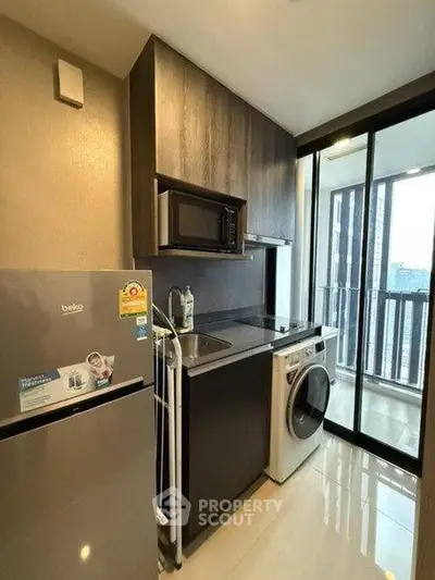Modern kitchen with sleek appliances and balcony view in a stylish apartment.