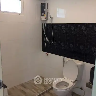 Modern bathroom with sleek shower and toilet in minimalist design.