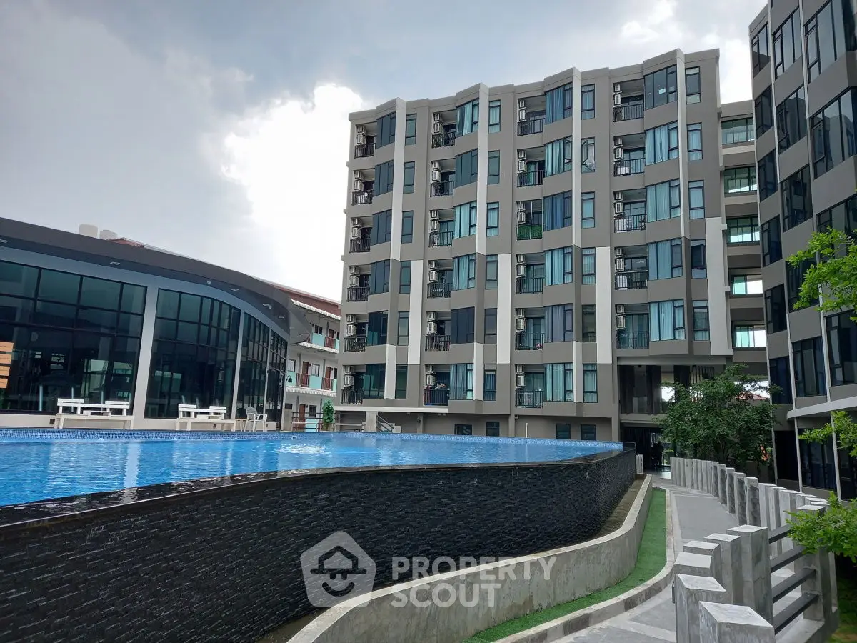 Modern apartment complex with luxurious pool and contemporary architecture.