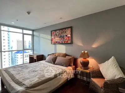 Spacious bedroom with city view, cozy decor, and natural light.