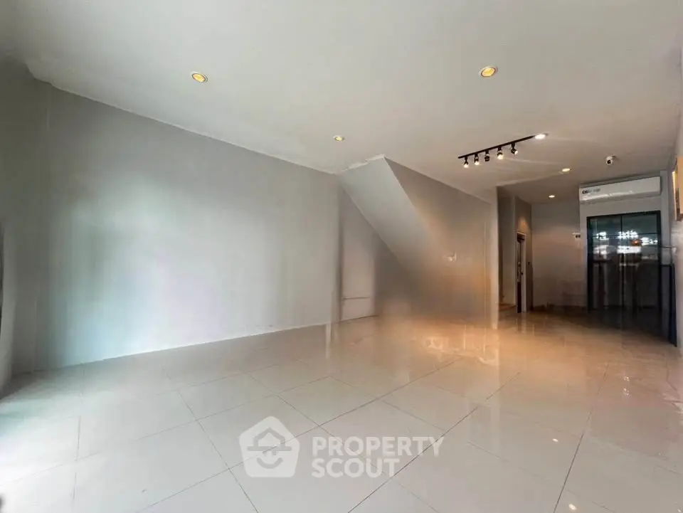 Spacious modern living room with sleek tile flooring and recessed lighting
