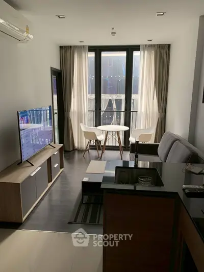 Modern living room with sleek furniture and large windows offering natural light.