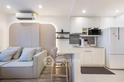 Modern open-layout kitchen and living room with sleek design and neutral tones.