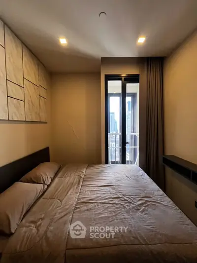 Cozy bedroom with city view and private balcony access, perfect for urban living.