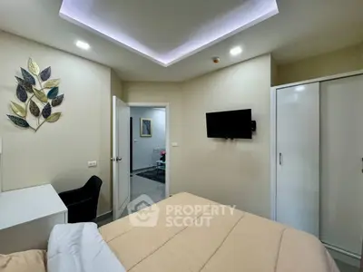 Modern bedroom with sleek design, featuring a wall-mounted TV and stylish decor.