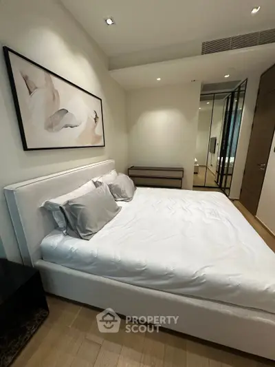 Modern bedroom with stylish decor and cozy ambiance, featuring a plush bed and elegant artwork.