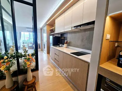 Modern open-layout kitchen with sleek cabinetry and integrated appliances in a stylish apartment.