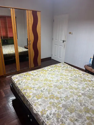 Cozy bedroom with floral mattress and mirrored wardrobe in a stylish apartment.