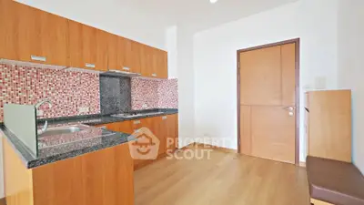 Modern kitchen with wooden cabinets and mosaic backsplash in a bright apartment.