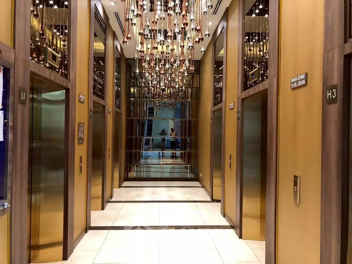 Luxurious elevator lobby with mirrored walls and elegant lighting fixtures.