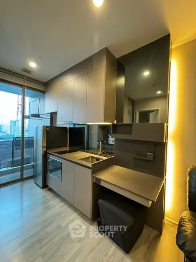 Modern kitchen with sleek cabinetry and open layout in a high-rise apartment with city view.