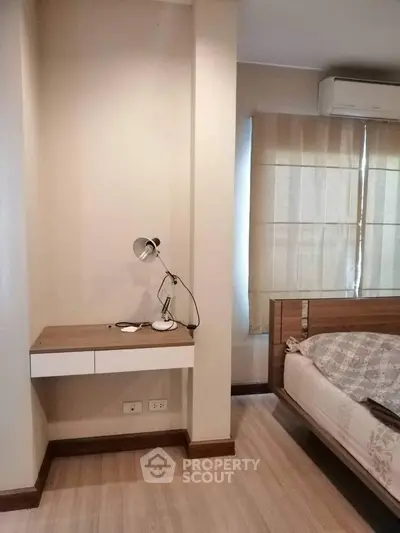 Cozy bedroom with modern design featuring a built-in desk and stylish lighting.