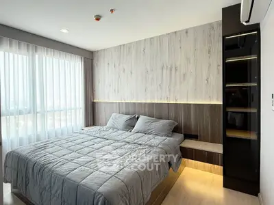 Modern bedroom with stylish wood paneling and large windows offering natural light.