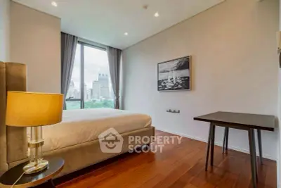 Modern bedroom with city view, elegant decor, and wooden flooring in a high-rise apartment.