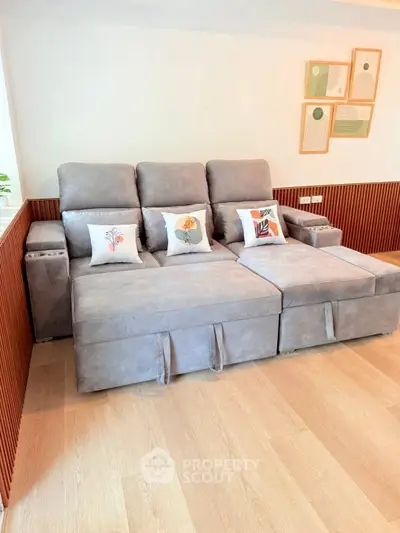 Modern living room with stylish grey sofa and decorative pillows, perfect for relaxation.