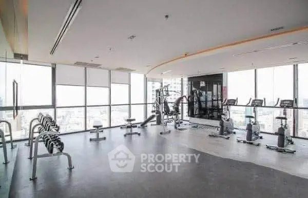 Spacious modern gym with panoramic city views and state-of-the-art equipment.