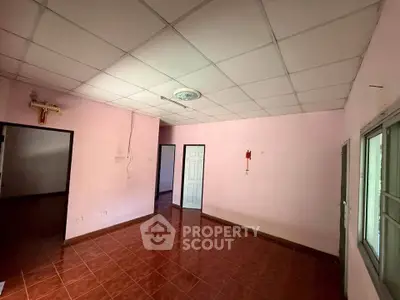 Spacious empty room with tiled floor and pink walls, ideal for customization.