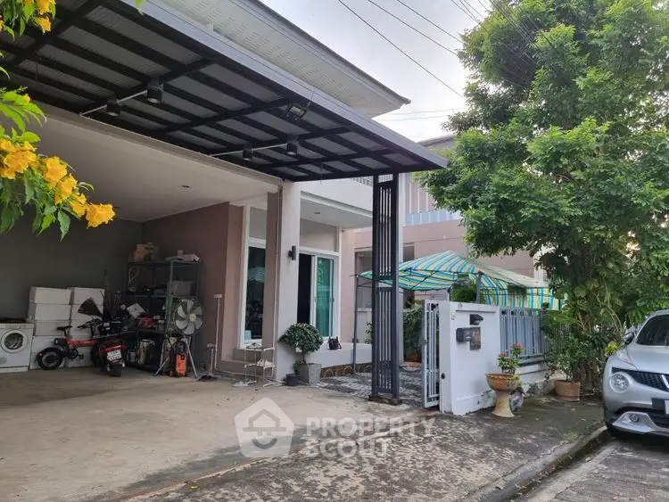 Modern house exterior with carport, lush greenery, and driveway