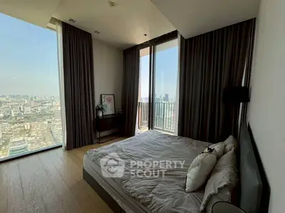 Luxurious bedroom with floor-to-ceiling windows offering stunning city views and modern decor.