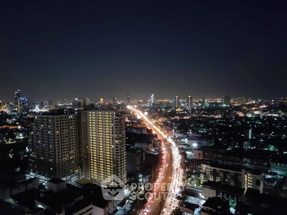 Stunning cityscape view from high-rise building at night with vibrant city lights.