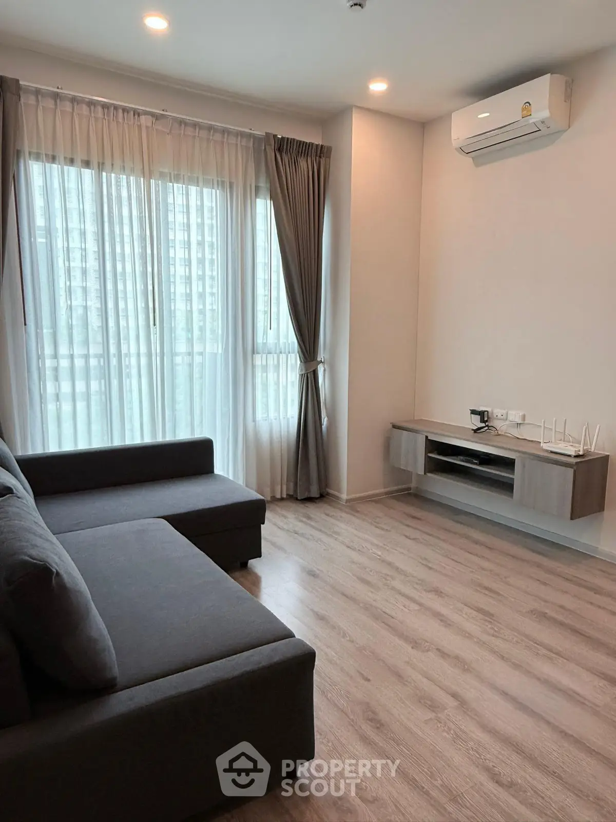 Modern living room with large window and air conditioning in a stylish apartment.