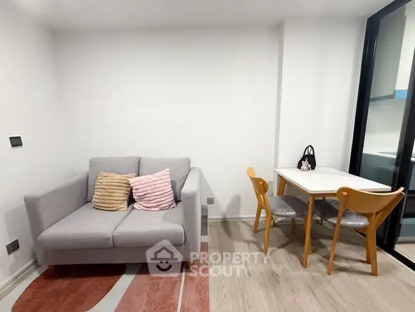 Modern living room with cozy sofa and dining area, featuring stylish decor and natural light.