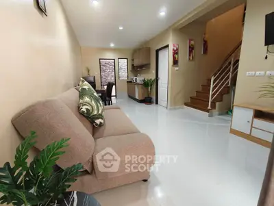 Spacious living room with modern decor and open kitchen layout in a stylish home.