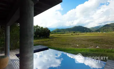 Stunning infinity pool with breathtaking mountain and field views, perfect for serene relaxation.