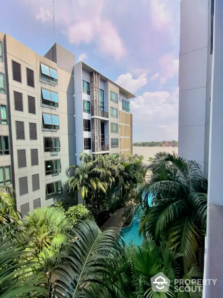 Modern apartment building with lush greenery and pool view