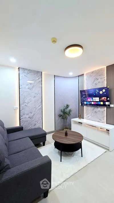 Modern living room with sleek design, featuring a cozy sofa, stylish coffee table, and wall-mounted TV.