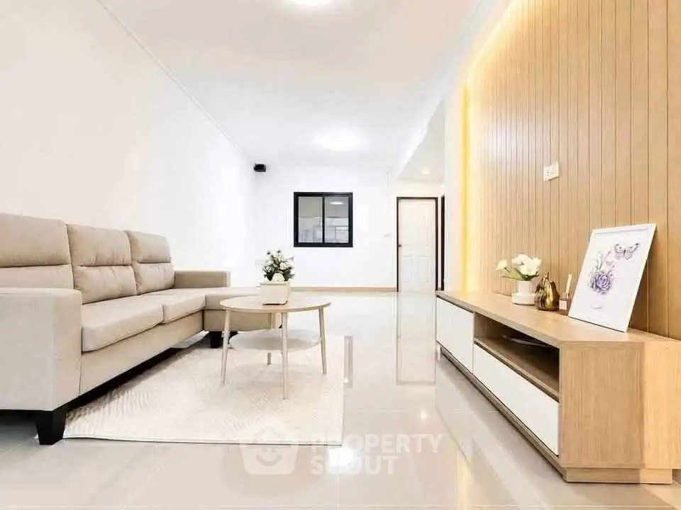 Modern living room with beige sofa, sleek coffee table, and stylish wooden paneling.