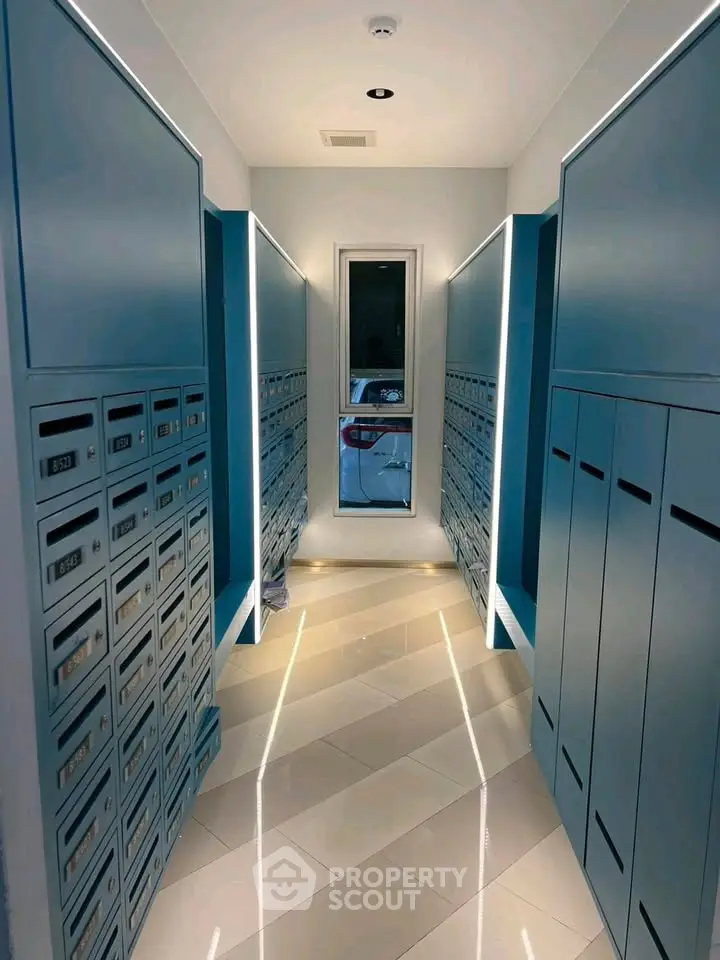 Modern apartment building mailroom with sleek blue lockers and ambient lighting.