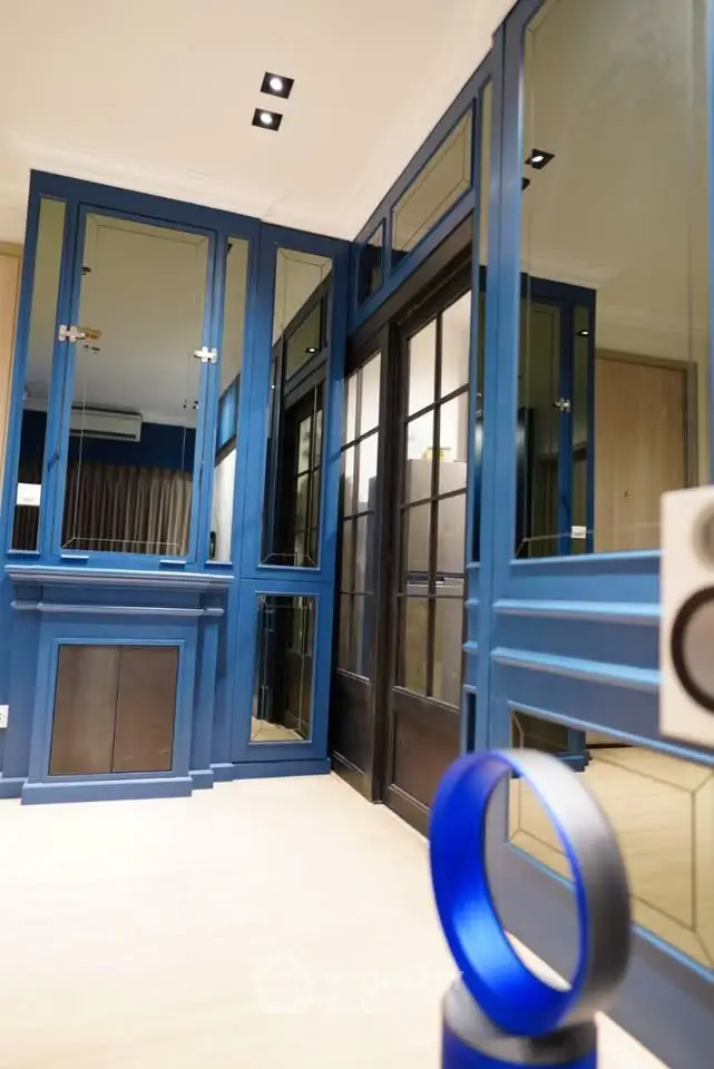 Stylish modern interior with blue cabinetry and mirrored accents, perfect for contemporary living.