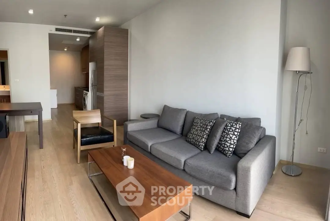 Modern living room with stylish furniture and open kitchen layout in a contemporary apartment.