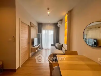 Modern living room with stylish decor and natural light, featuring a cozy sofa and wall-mounted TV.