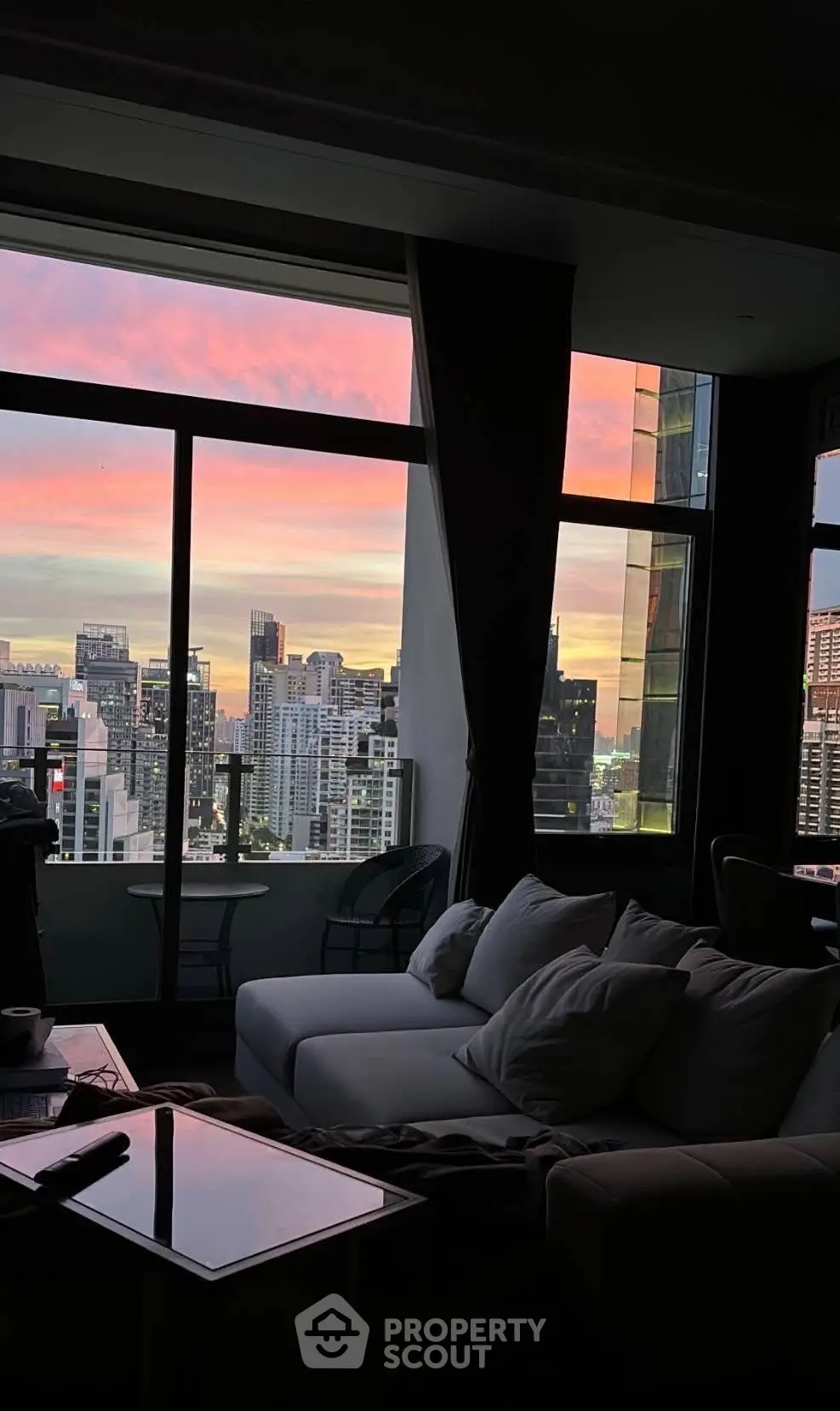 Luxurious living room with stunning city skyline view at sunset