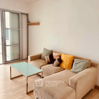 Cozy living room with modern beige sectional sofa and glass coffee table, perfect for relaxation.