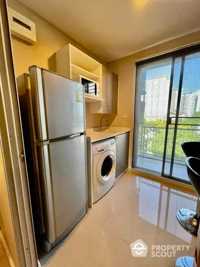 Modern kitchen with appliances and balcony view in urban apartment