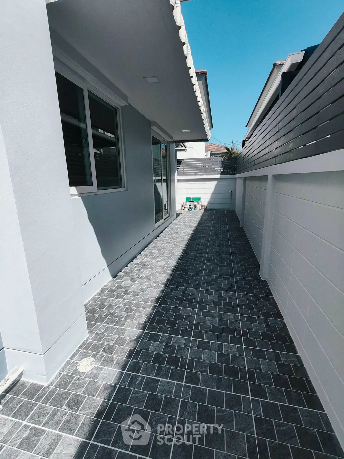 Modern exterior side pathway with sleek tiled flooring and contemporary design.