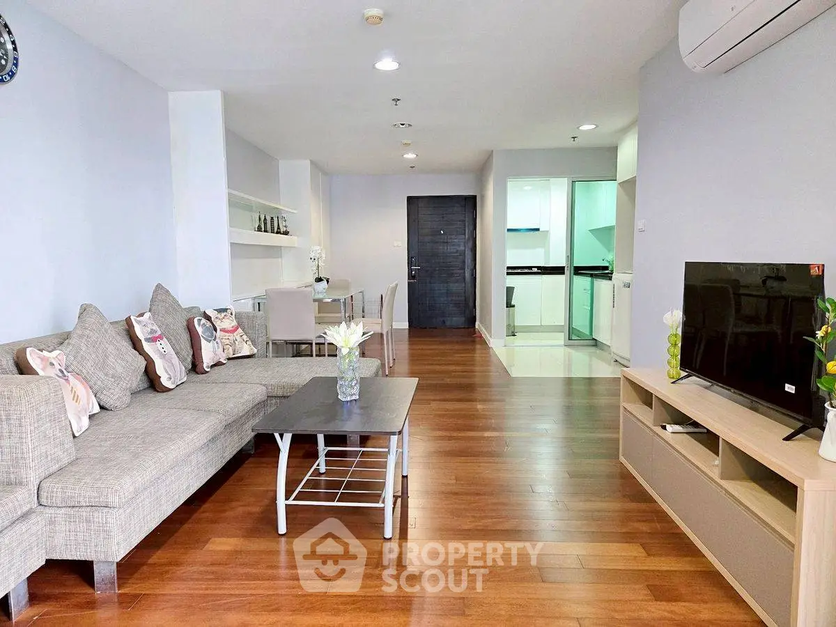 Spacious modern living room with hardwood floors and open kitchen layout