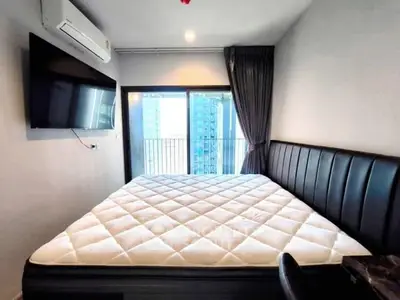 Modern bedroom with large bed and city view balcony in luxury apartment.