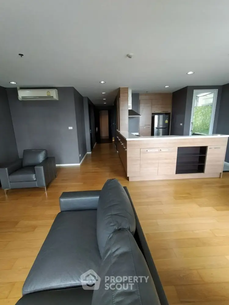 Spacious modern living room with open kitchen and sleek leather furniture