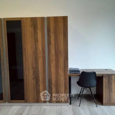 Modern study area with sleek wooden wardrobe and minimalist desk in a stylish apartment.