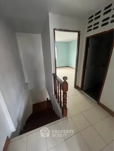 Spacious interior hallway with staircase and tiled flooring in a modern home
